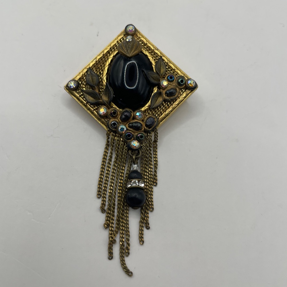 Elegant Gold and Black Brooch with Chain Tassels